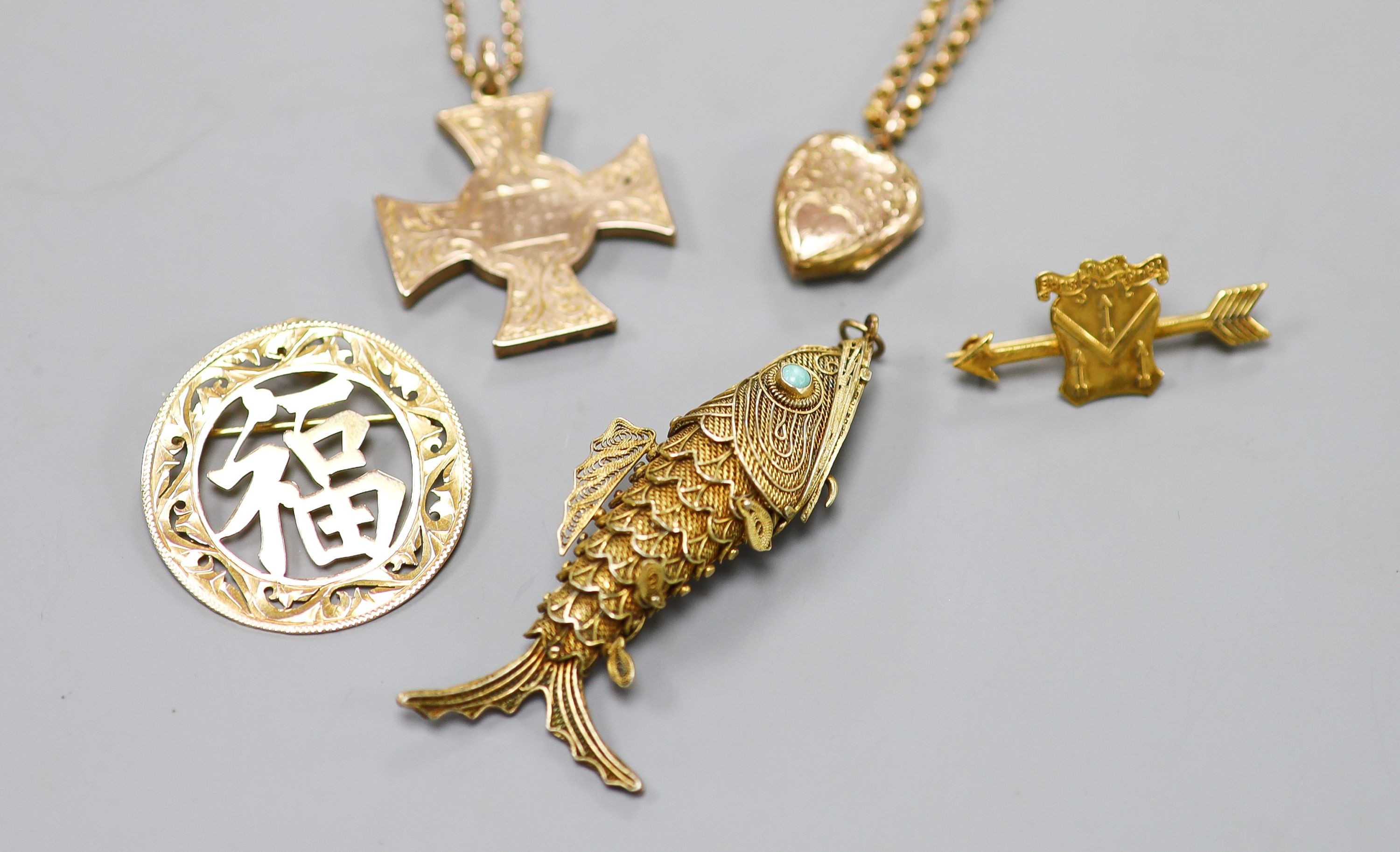 A Scottish yellow metal cross pendant on a 9c chain, a similar heart locket on a gilt metal chain, a Chinese 9k pendant brooch, a 9ct gold arrow brooch, a 9c chain(a.f.) and a filigree fish pendant